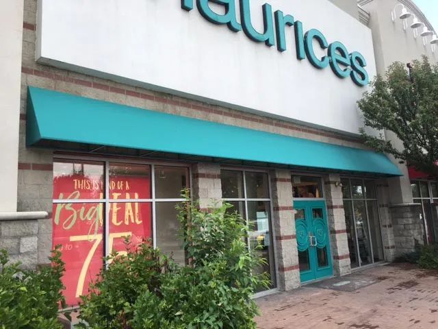 A store front with a blue awning that says ' sources ' on it.