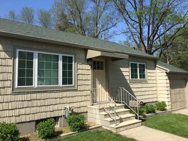 A house with stairs leading up to the front door and a garage.
