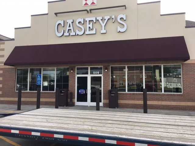 A casey 's store with a trailer parked in front of it.