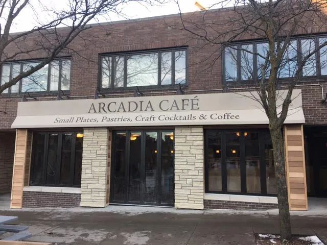 A building with a sign that says ' arcadia cafe ' on it.