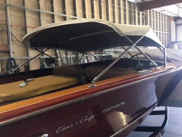 A boat with a canopy is sitting in a garage.
