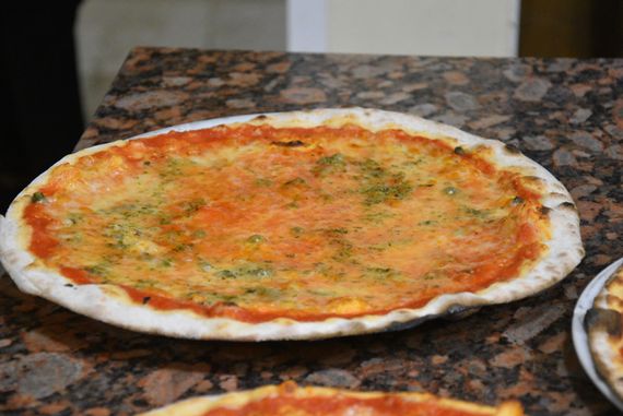 Il pizzaiolo Valentino Izzo che mostra una selezione di ingredienti di stagione