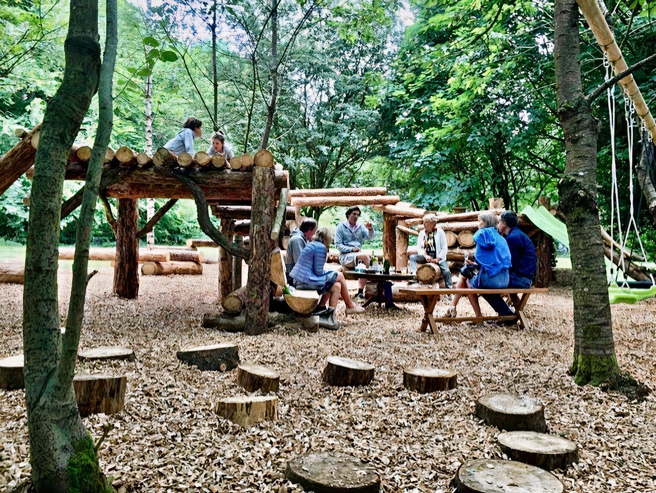 Un groupe de personnes sont assises à une table de pique-nique dans les bois.