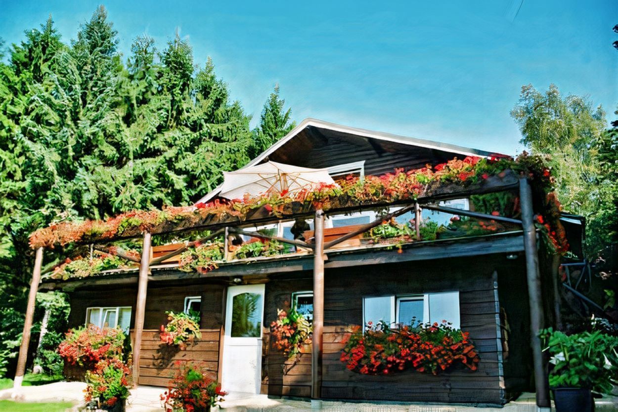 Une maison en bois avec des fleurs sur le devant