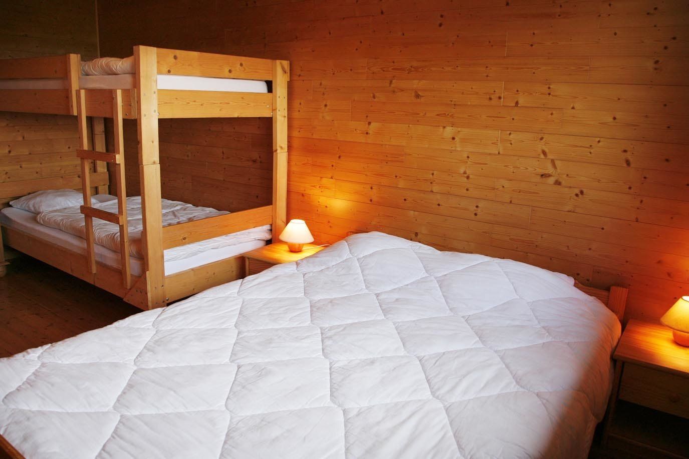 Een slaapkamer met twee stapelbedden en een bed