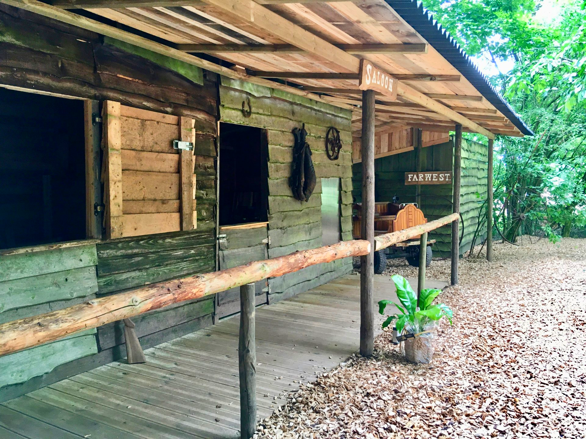 Een houten gebouw met een overdekte veranda en een houten balustrade.