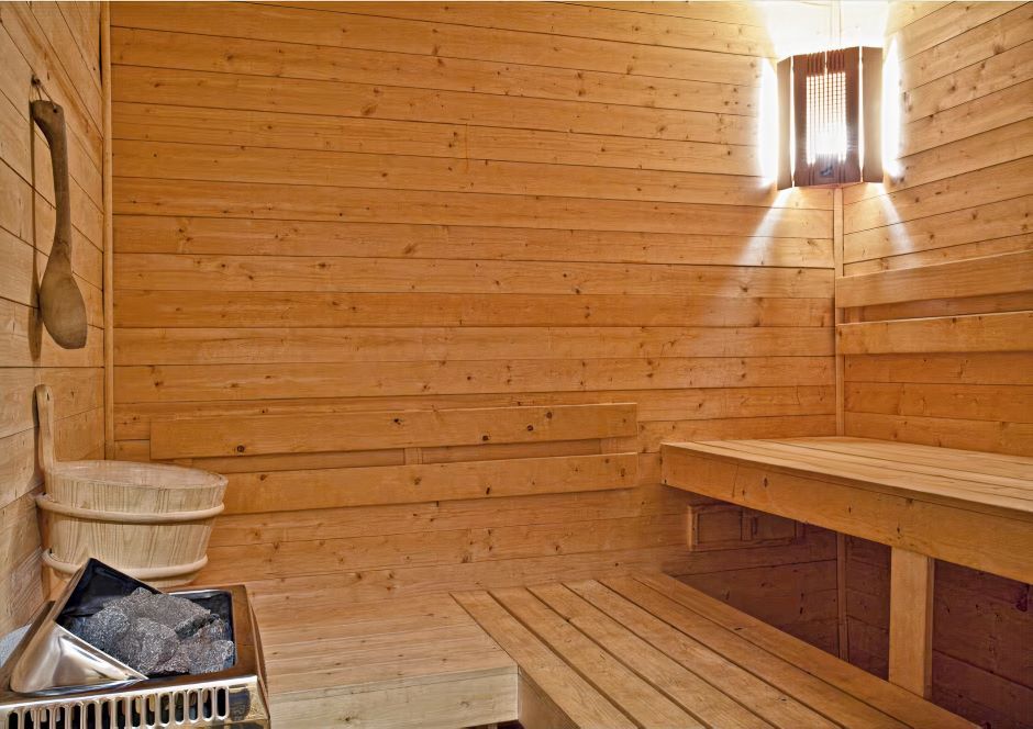 Un sauna en bois avec des bancs en bois et un seau.