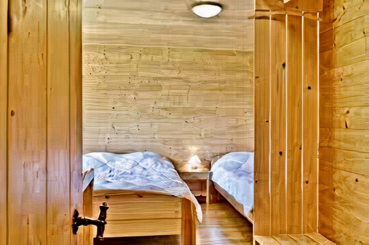 Une chambre en bois avec deux lits et une armoire.