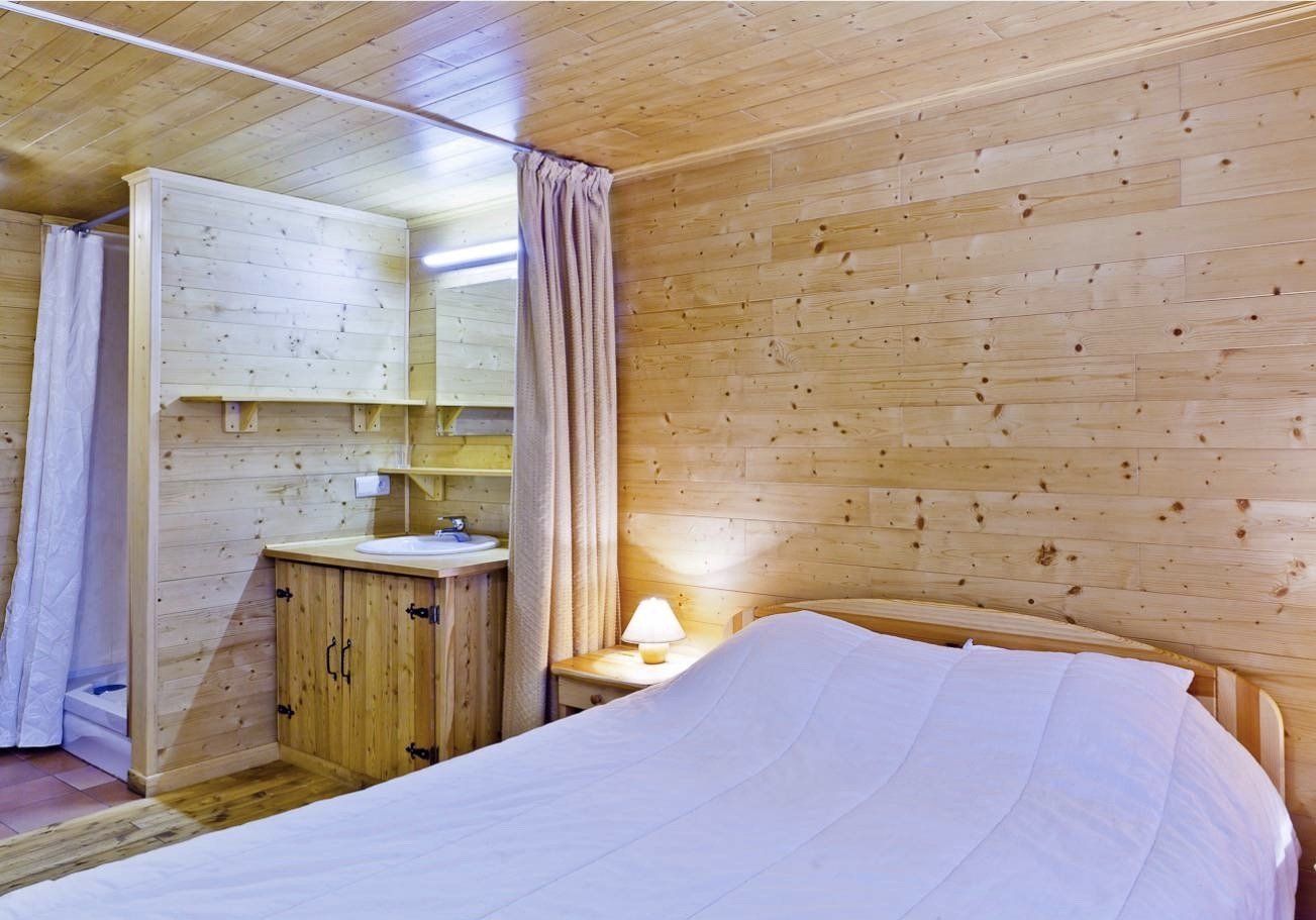 Une chambre avec un lit, une table de nuit, un lavabo et un miroir.