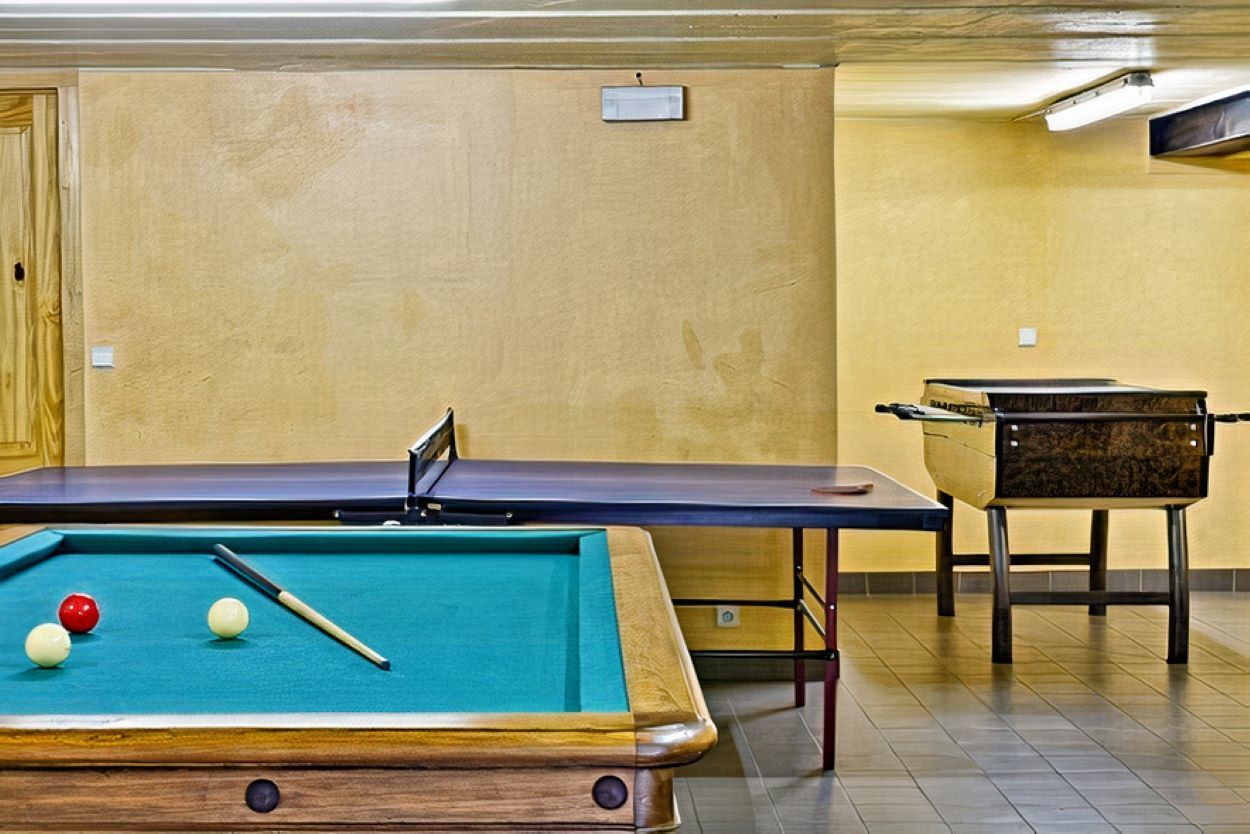 Il y a une table de billard et une table de ping-pong dans la chambre.