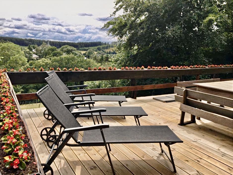 Une rangée de chaises longues est installée sur une terrasse en bois.