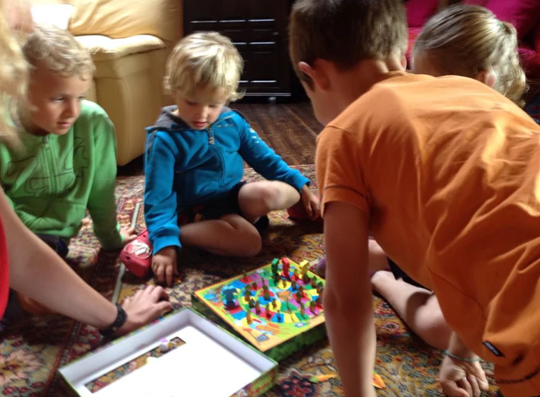 Un groupe d'enfants joue à un jeu de société sur le sol