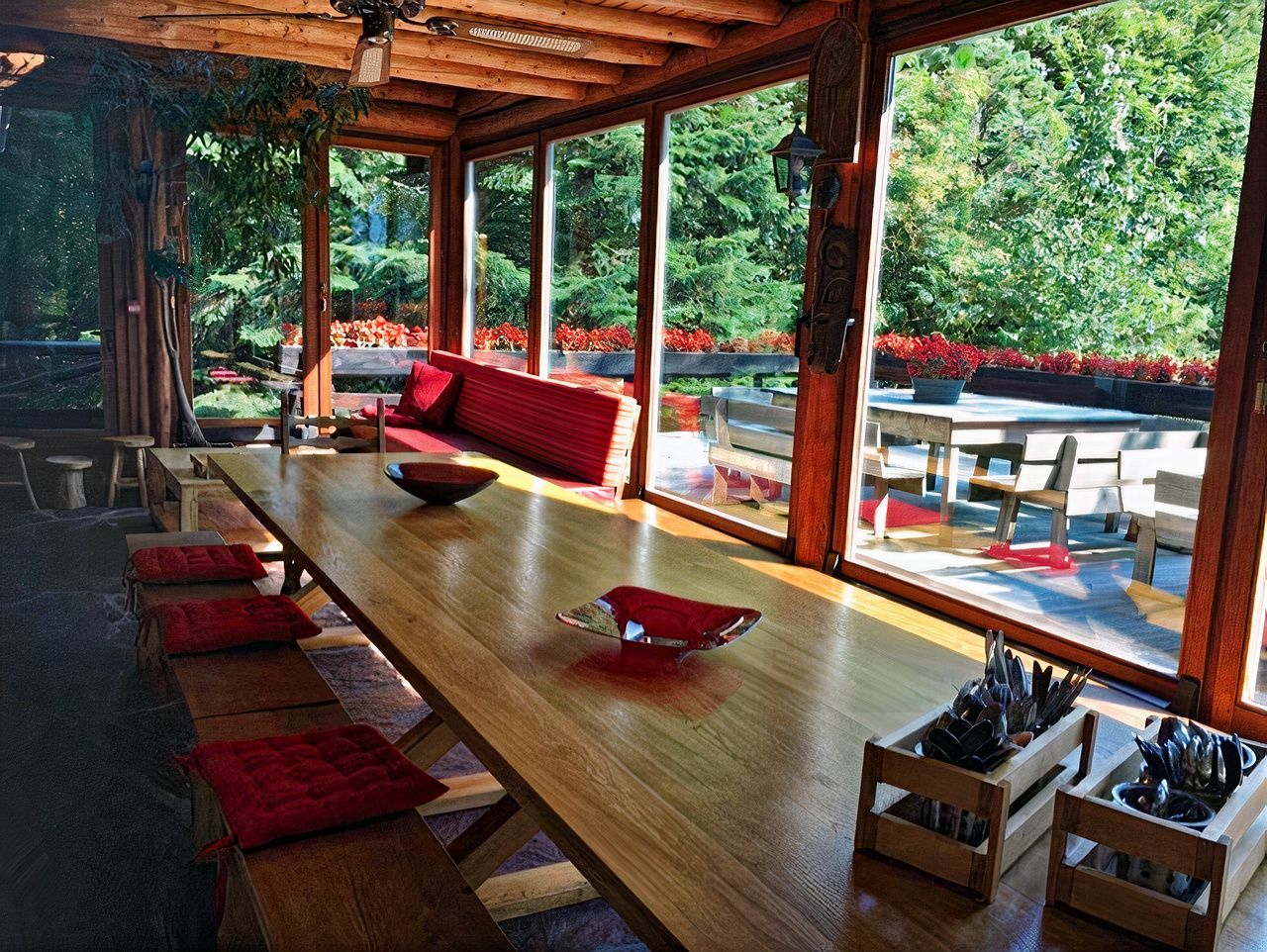 Une longue table en bois dans une pièce avec beaucoup de fenêtres