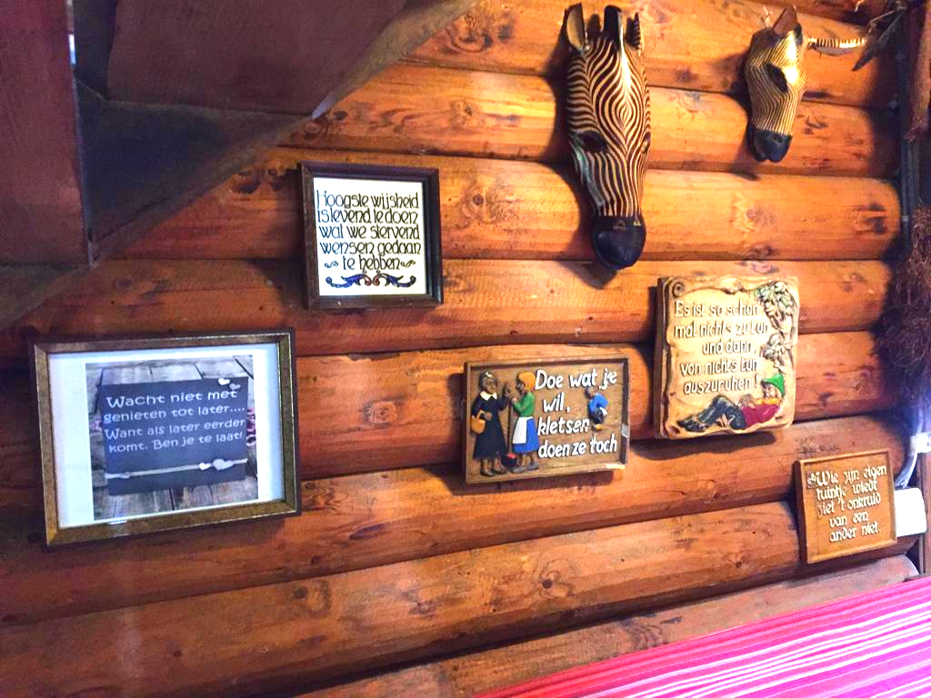 Een houten wand met foto's en een zebrakop erop