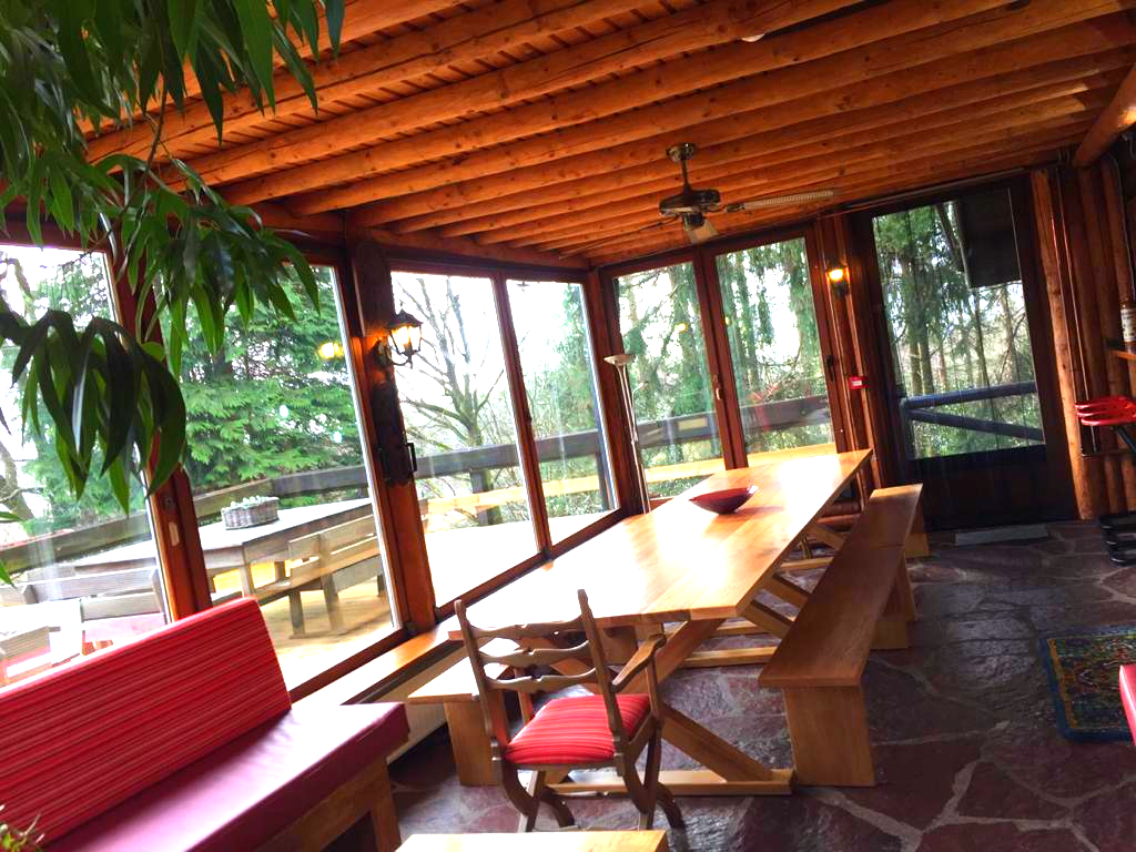 Een kamer met een lange tafel en banken erin