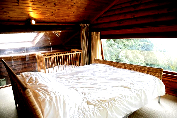 Een slaapkamer met een groot bed en een raam.