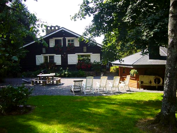 Een huis met een picknicktafel en stoelen ervoor