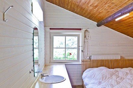 Een badkamer met een wastafel, een spiegel en een bed