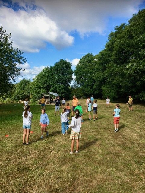 Een groep kinderen speelt frisbee op een grasveld