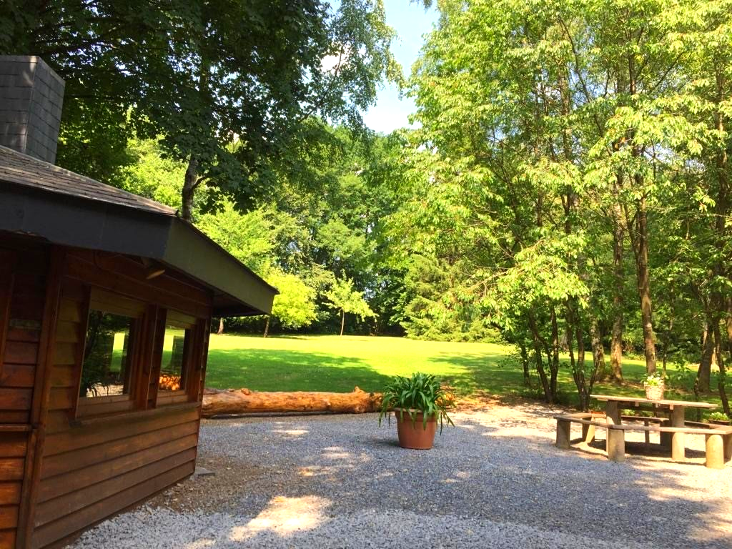 Een houten huis met een picknicktafel ervoor
