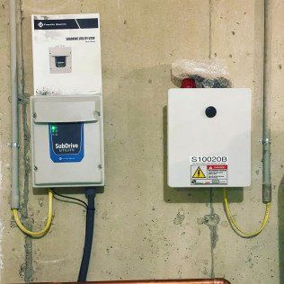 Two electrical boxes are connected to a wall.