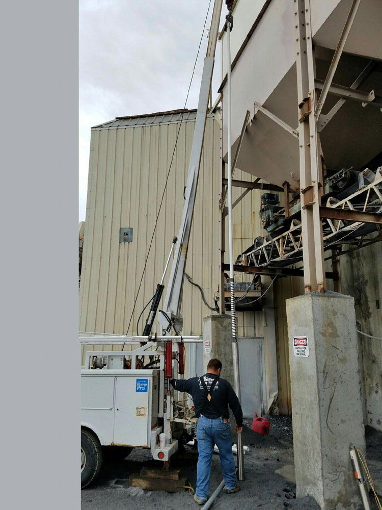A man is standing next to a crane in front of a building.