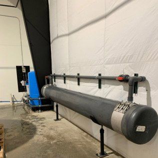 A long pipe is hanging on a wall in a room.