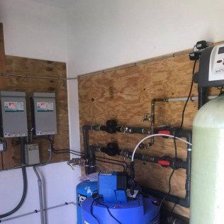 A room with a lot of pipes and a blue tank.