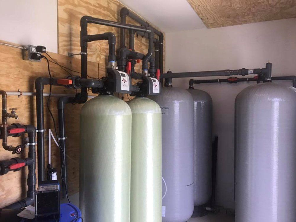 A room filled with lots of gray tanks and pipes.