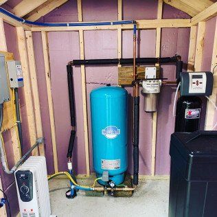 A blue water tank is sitting inside of a shed.
