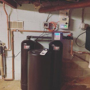 A couple of black tanks sitting next to each other in a basement.