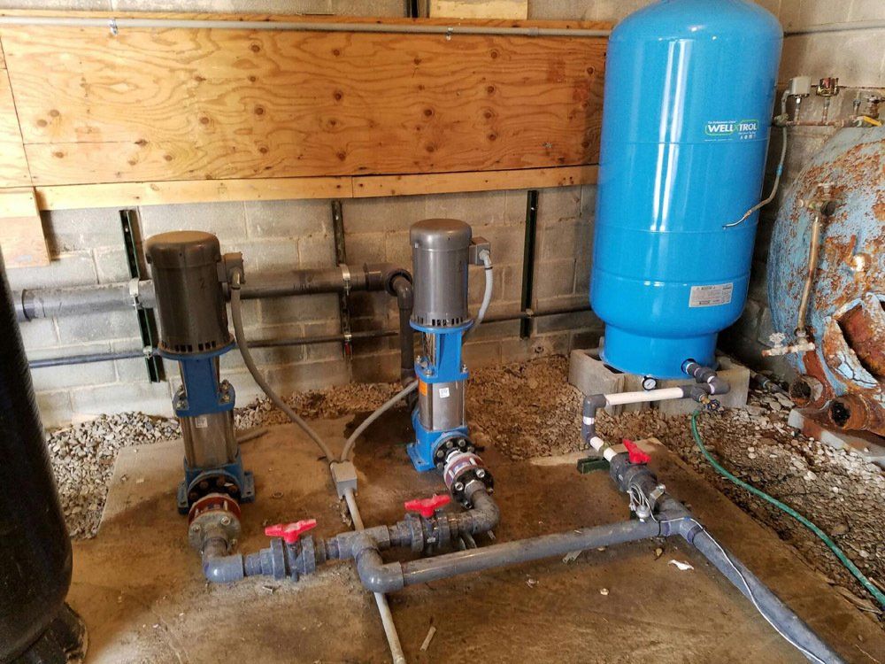 A room with a lot of pipes and a blue tank.