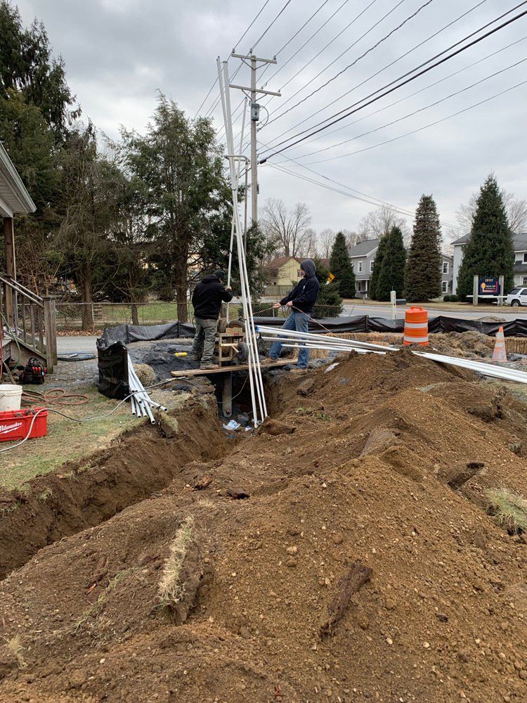 A pile of dirt is sitting on the side of a road next to a power line.