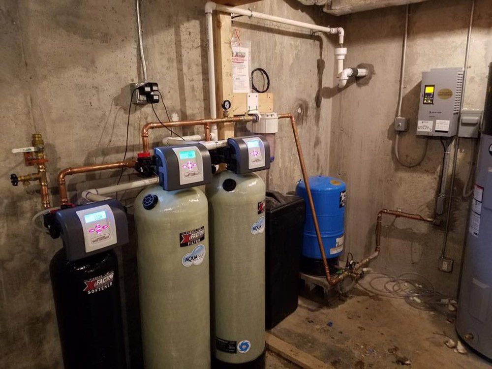 A room with a lot of pipes and a water heater.