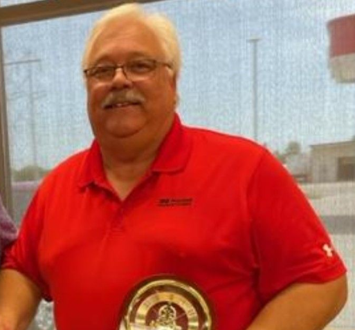 Woman with blonde hair wearing a white blazer, smiling at the camera.
