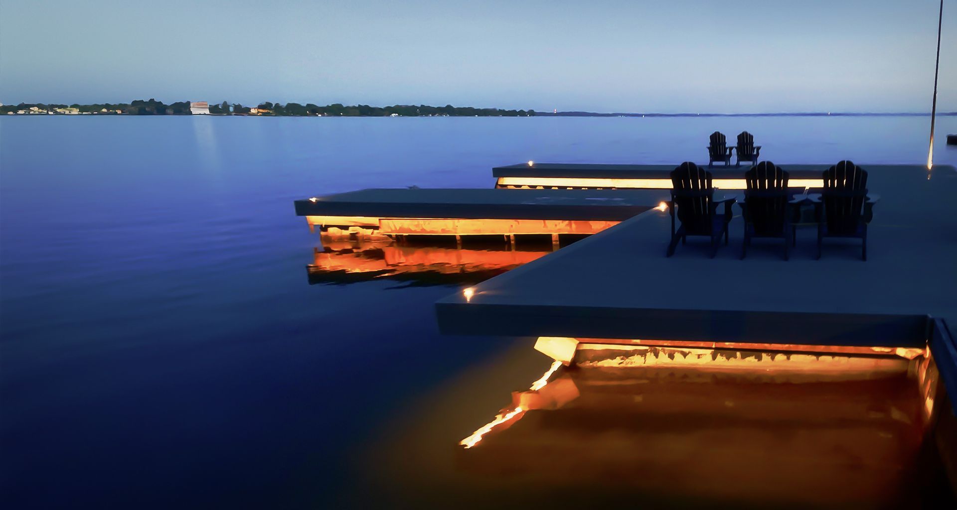 A couple of chairs sit on a dock overlooking a body of water