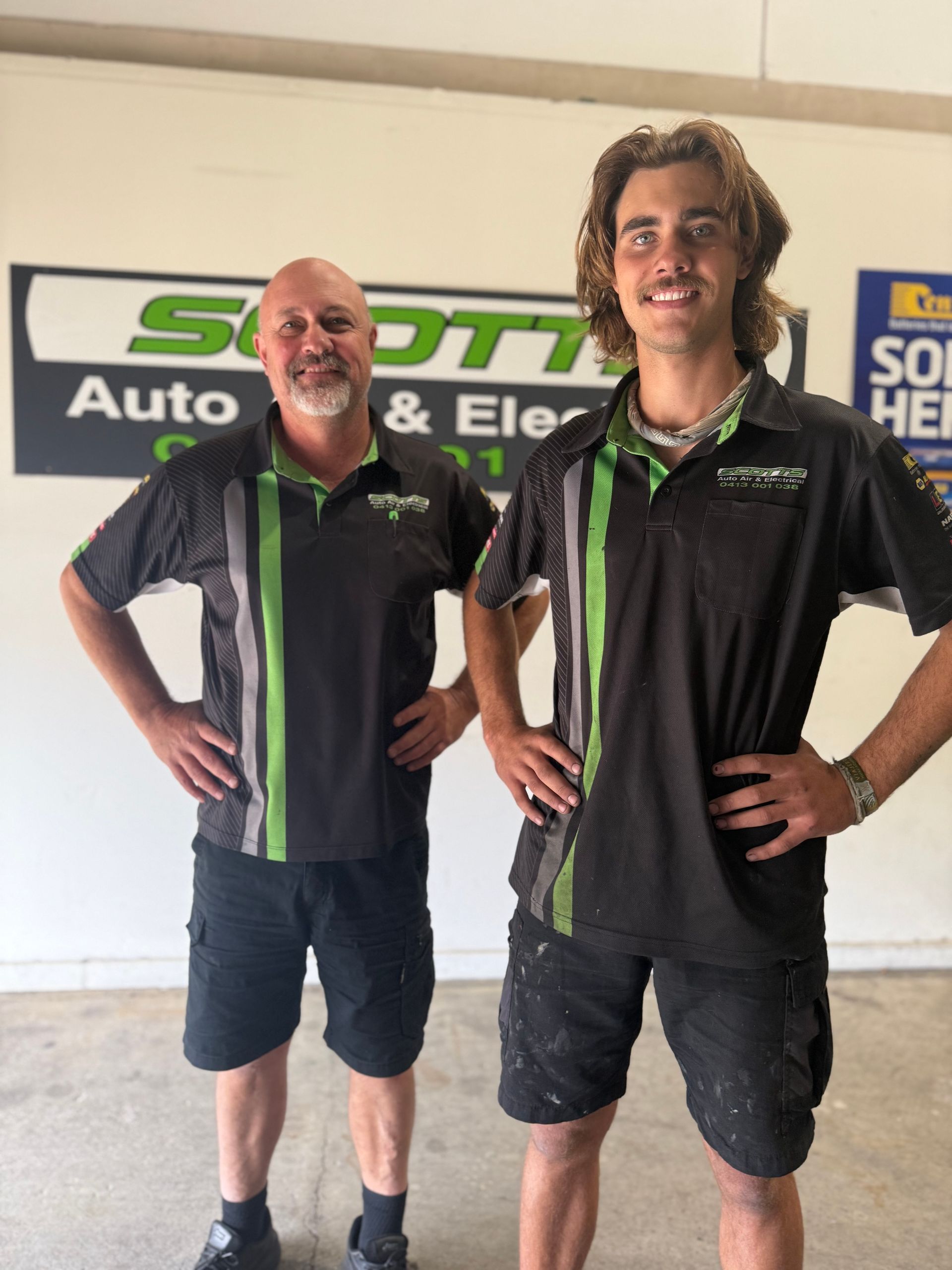 Two Mechanics Standing in Front of a Wall Sign— Scotts Auto Air & Electrical In Wollongong, NSW