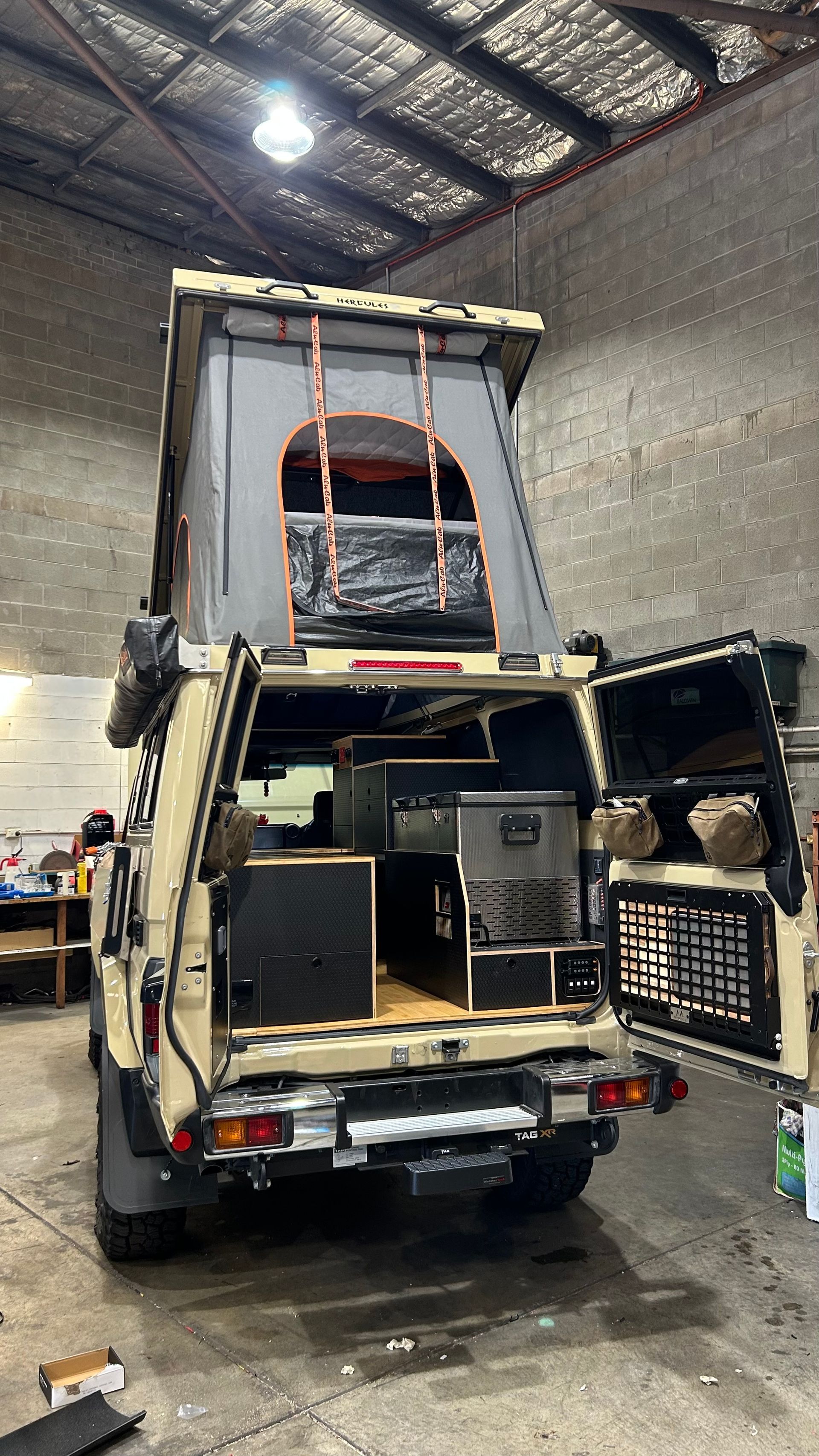 Back of a four wheel drive is open showing the fit out with a pop up tent on top — Scotts Auto Air & Electrical In Wollongong, NSW