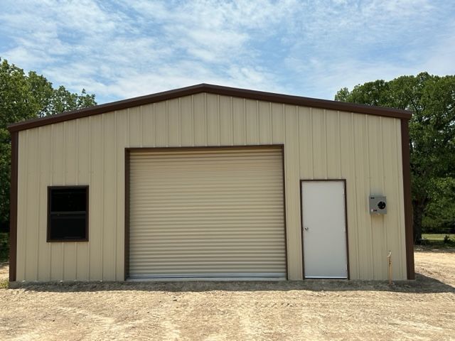 A building with a garage door and a white door