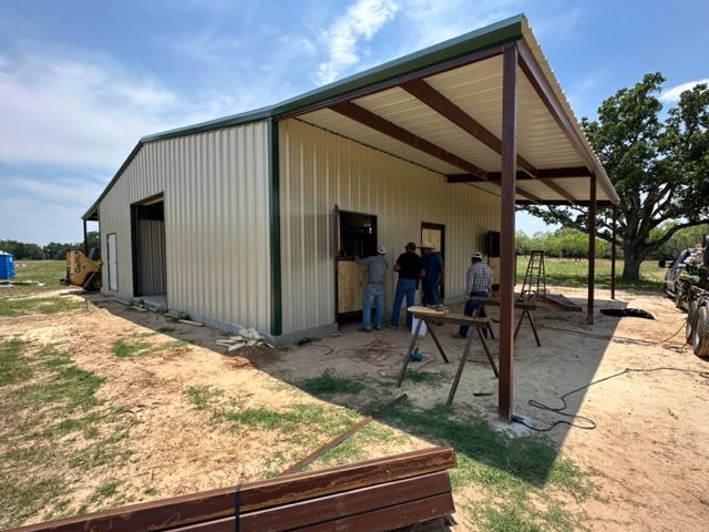 A group of people are working on a metal building.