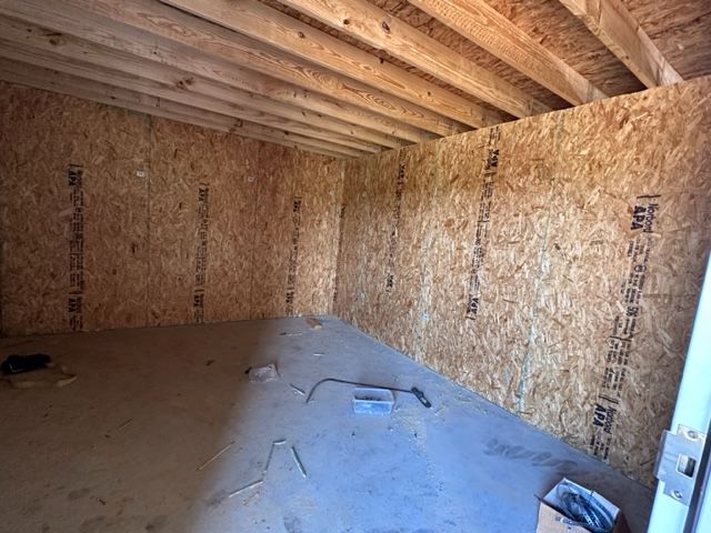 A room with a lot of wooden beams and a door.