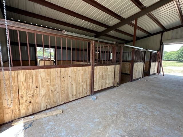 A row of wooden horse stalls in a barn.