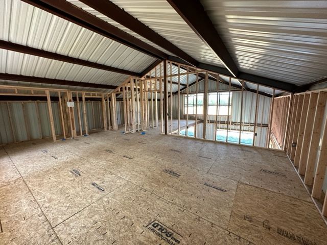 An empty room with a wooden floor and a metal ceiling