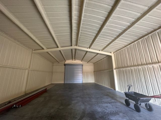There is a wheelbarrow in the middle of the garage.