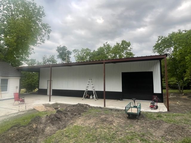 A white building with a black door and a ladder in front of it