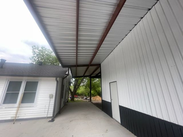 A white building with a metal roof and a door