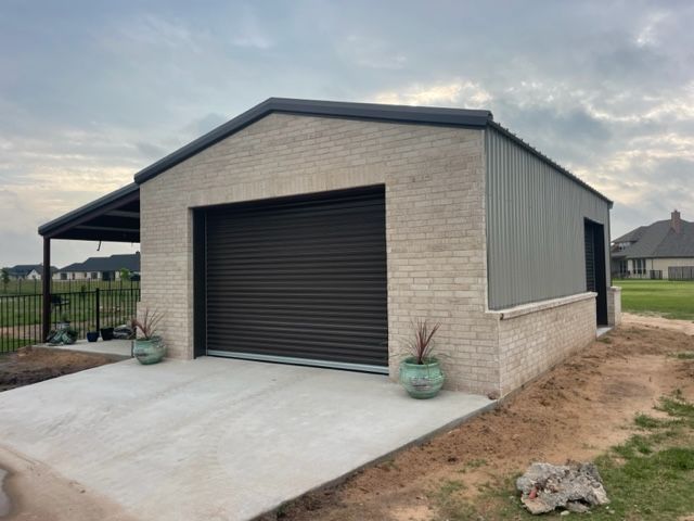 A garage with a black door and a brick wall