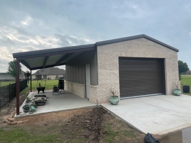 A garage with a covered porch and a garage door.