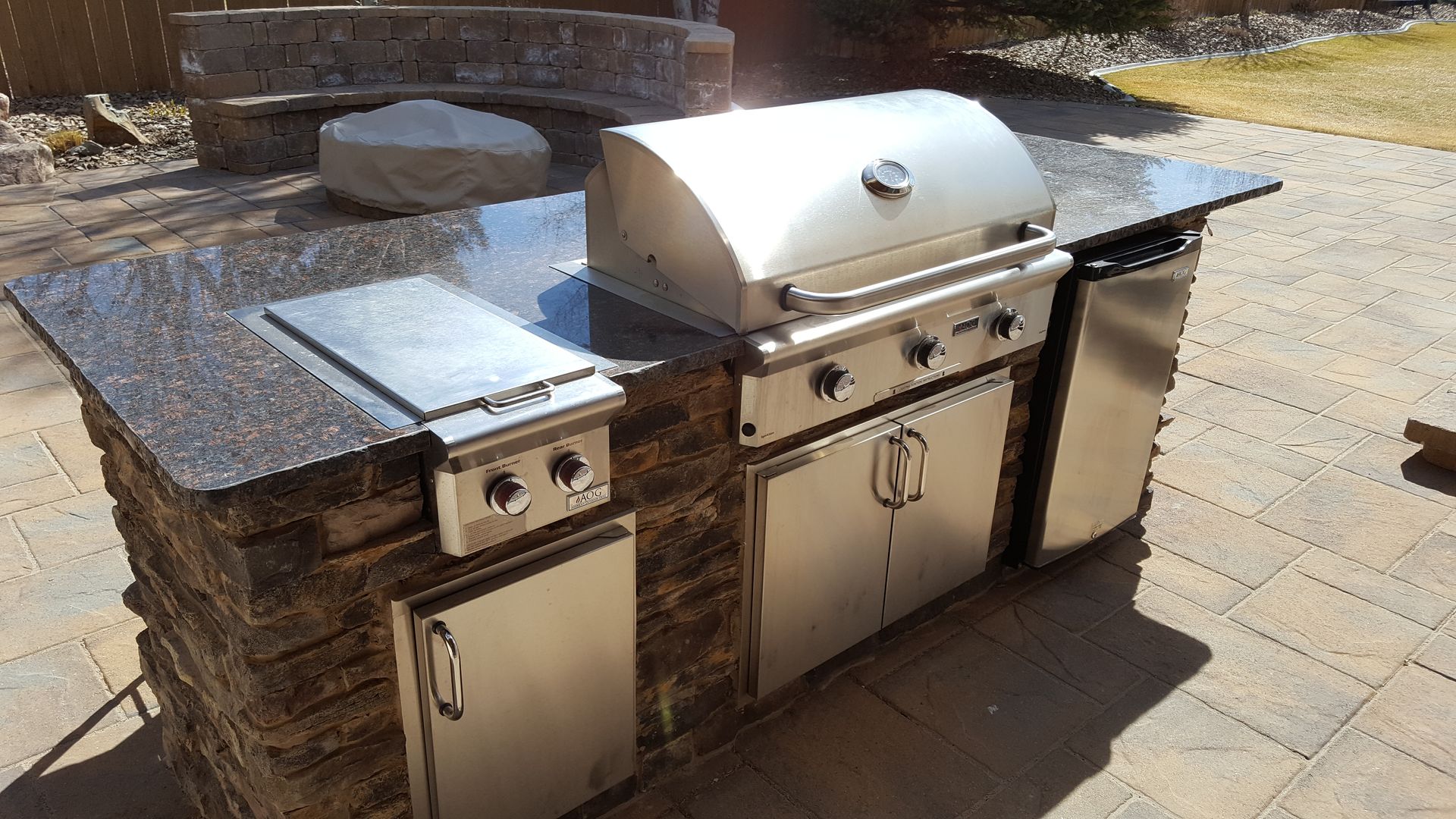 A stainless steel grill is sitting on top of a granite counter top.