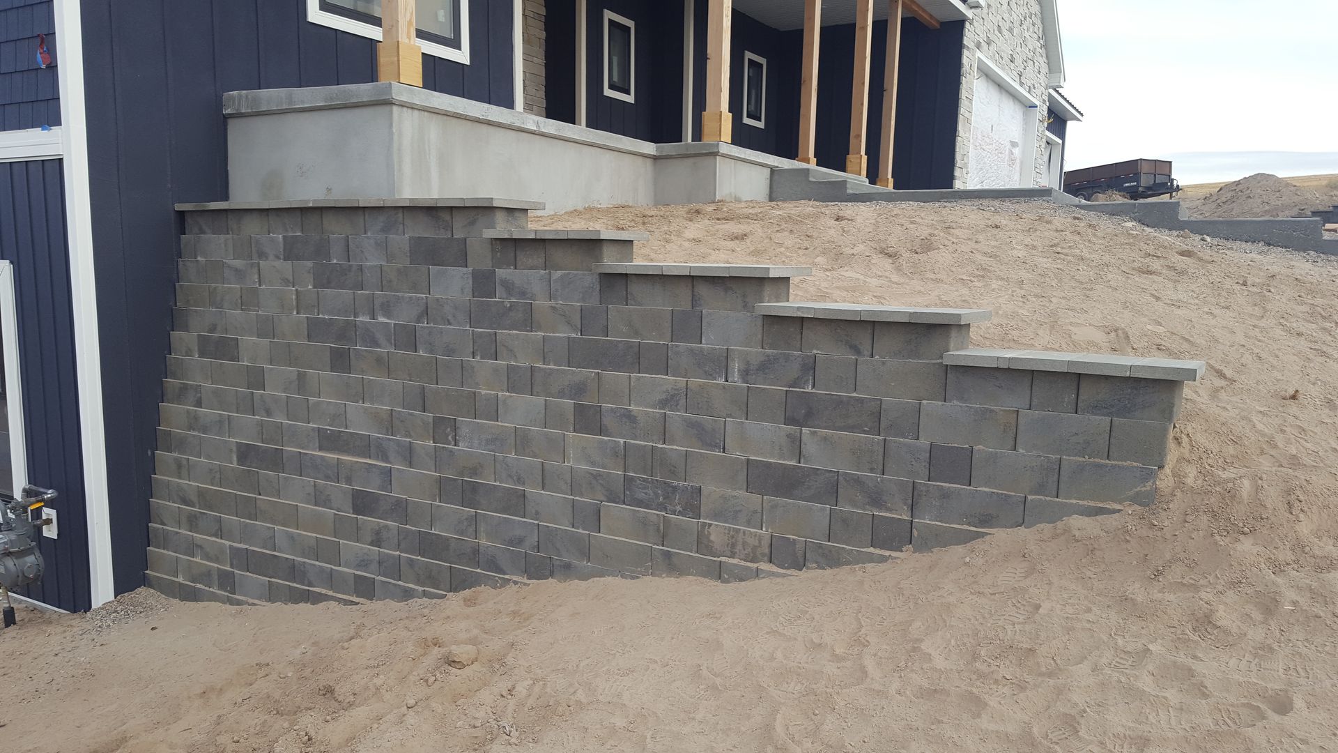 A brick wall with stairs leading up to a house.